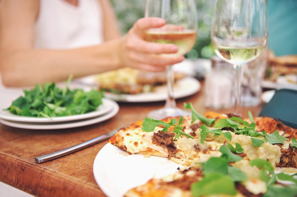 Deep Creek Restaurants, woman having pizza and white wine at a casual eatery 